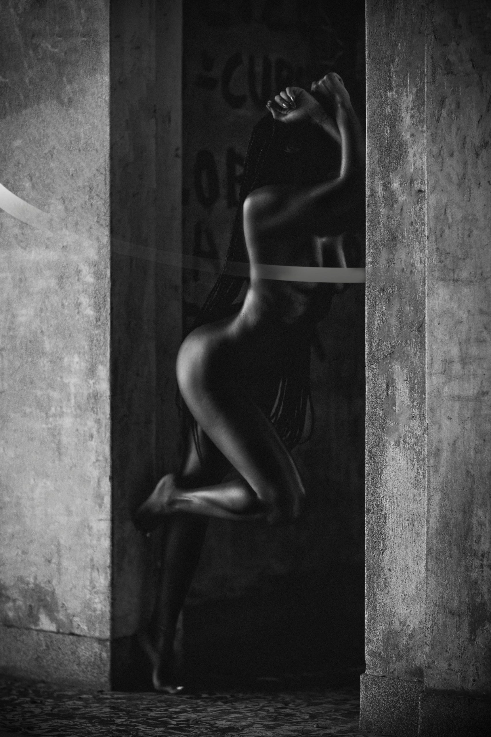 Elegant silhouette of a woman posing artistically in soft black and white tones.